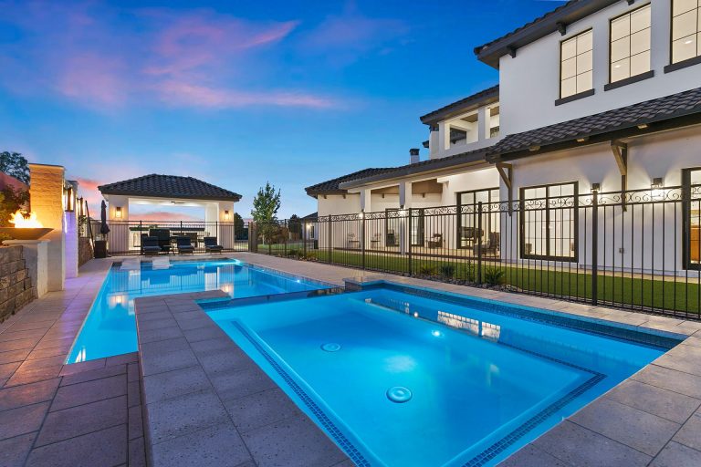 Two-story house with a large swimming pool.