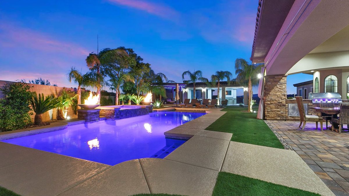 Luxury backyard pool with LED lighting, fire features, and custom patio design by H And H Pools LLC in Las Vegas.