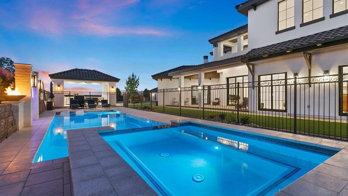 Two-story house with a large swimming pool.