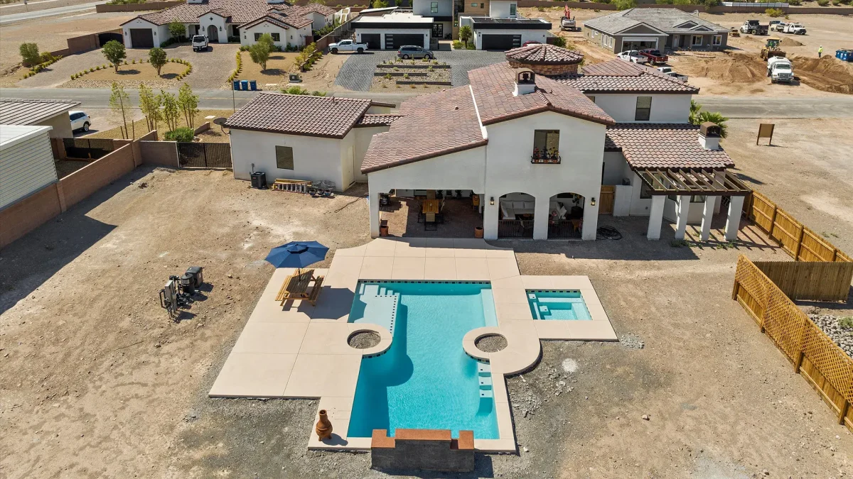 Arial view of a home with a large backyard, pool and spa.