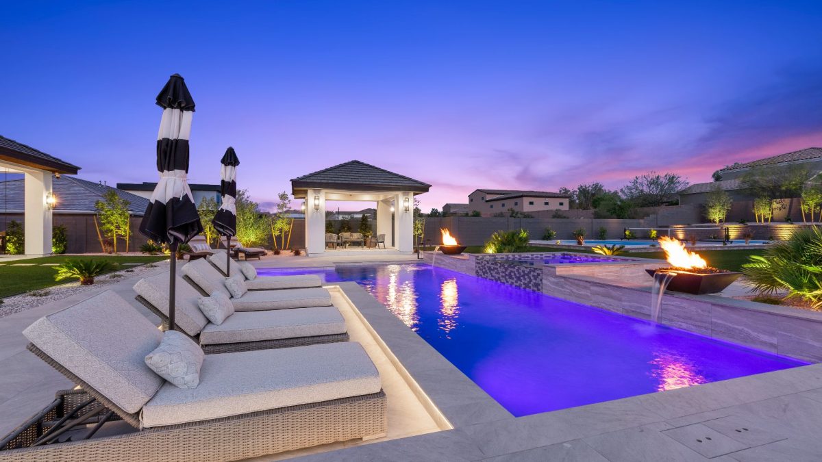 Swimming pool lined with chairs and a cabana