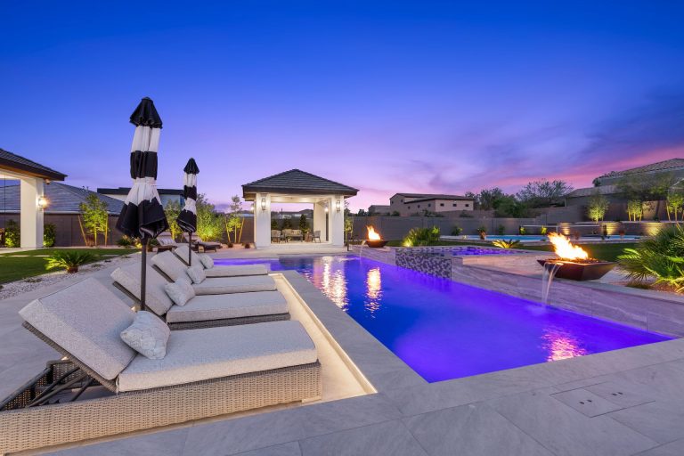 Swimming pool lined with chairs and a cabana